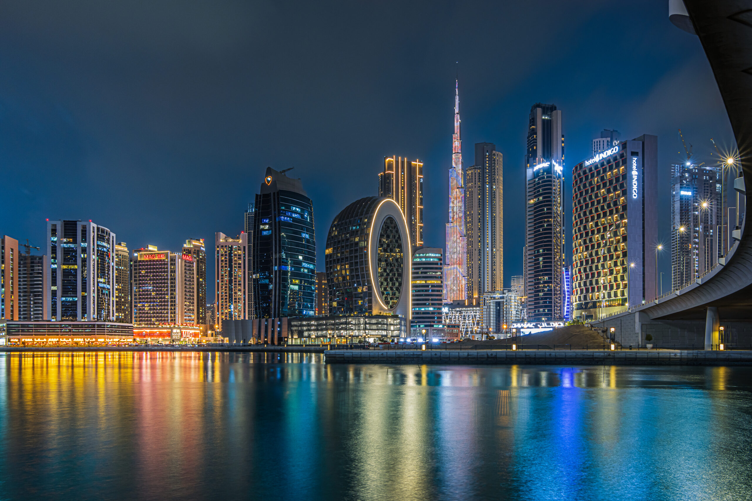 modern buildings in the city center of dubai in the evening. illuminated skyscrapers in the financial center at the blue hour. view of skyline in united arab emirates at night and reflection